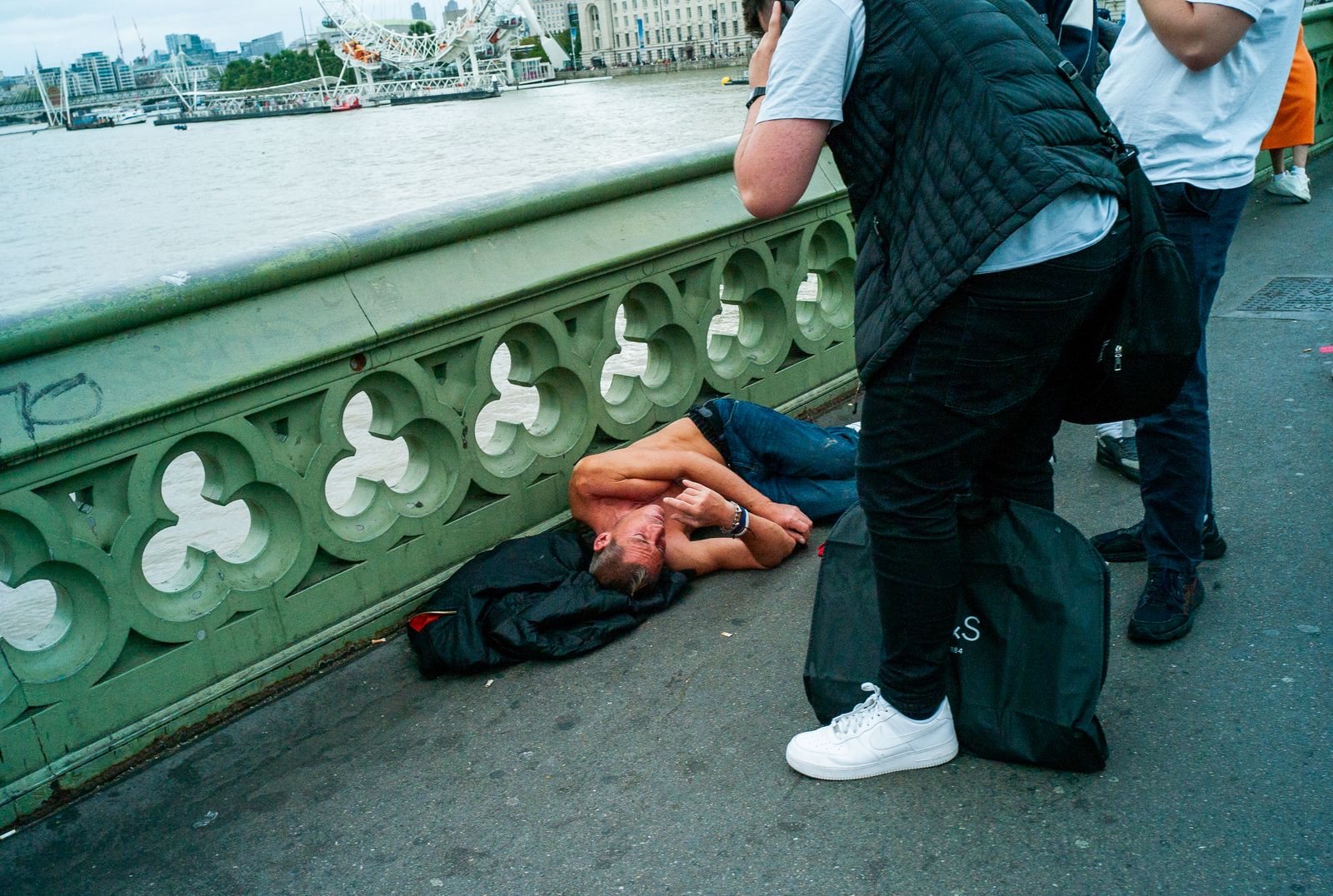 a man laying on the ground next to a body of water