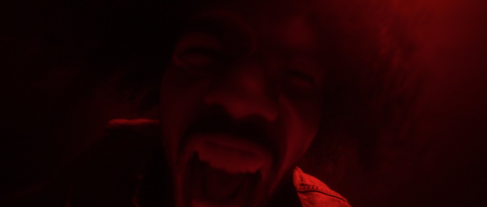 a person with their mouth open in a dark room