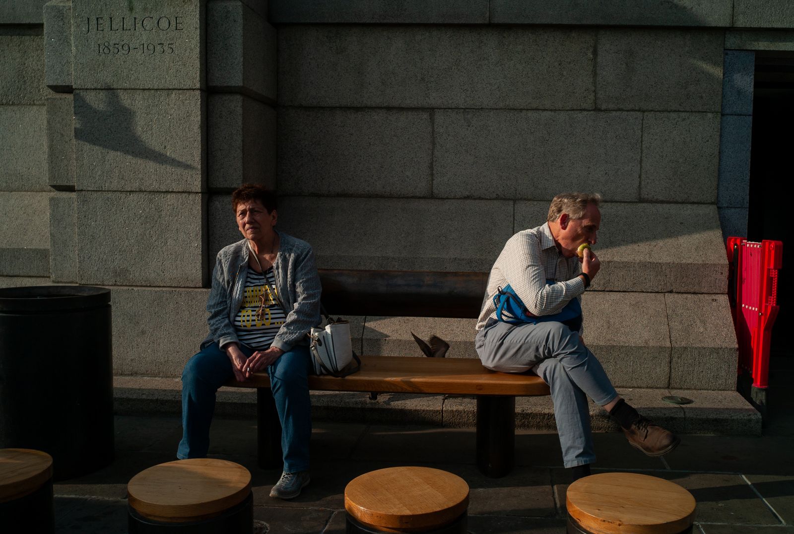 two people sitting on a bench in front of a building