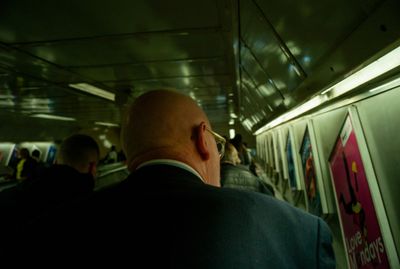 a man in a suit looking out the window of a train