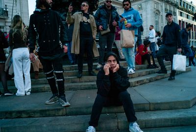 a woman sitting on the steps in front of a group of people