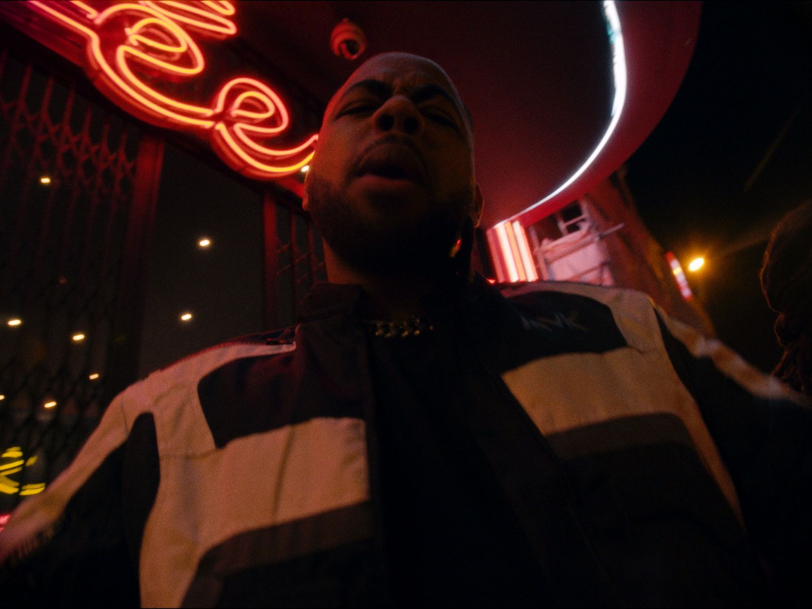 a man standing in front of a neon sign