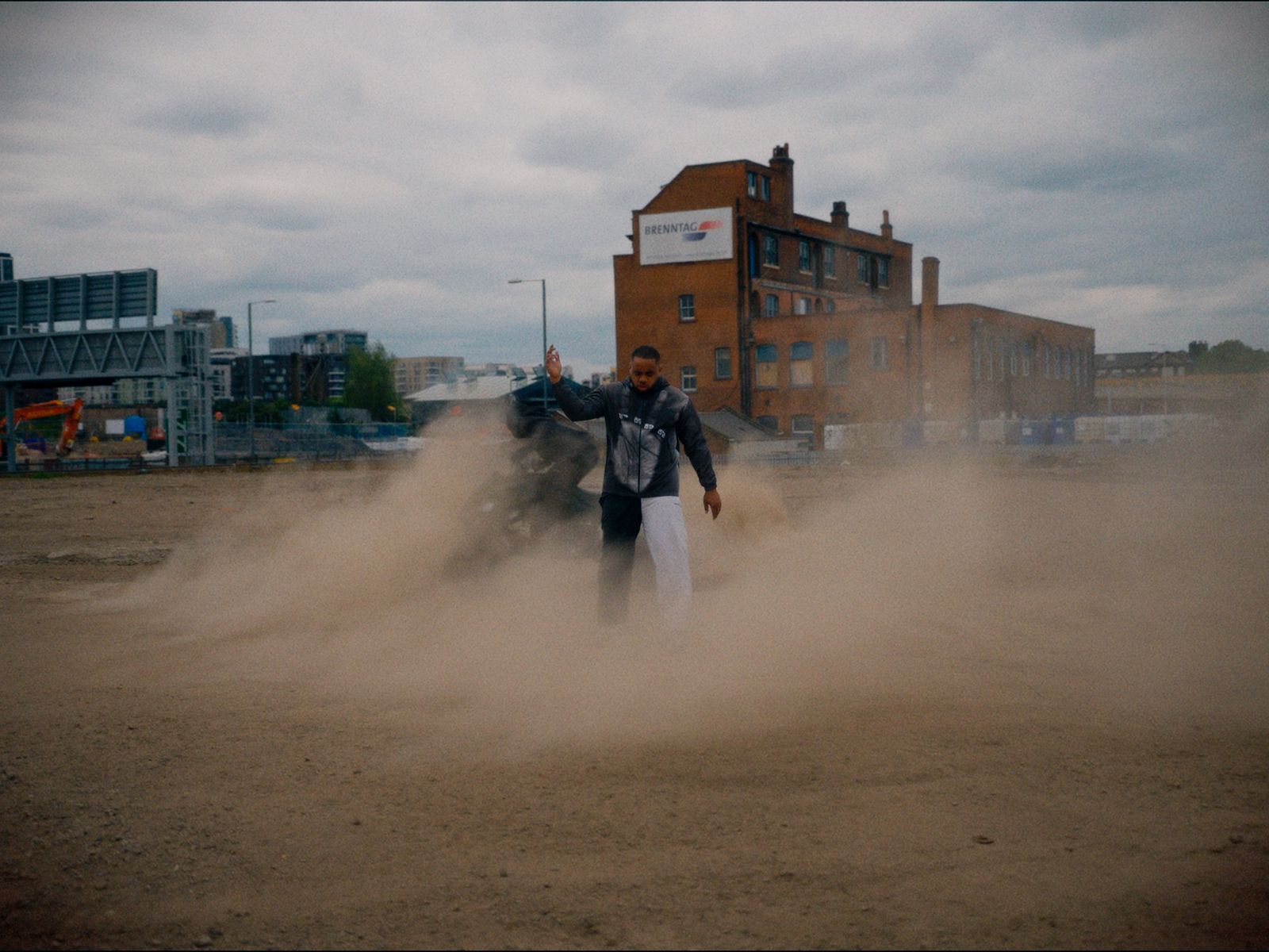a man standing in the middle of a dirt field