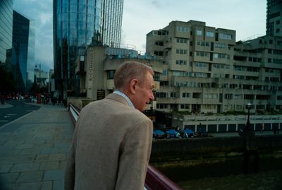 a man standing on a bridge in front of a city