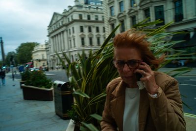 a woman talking on a cell phone on a city street