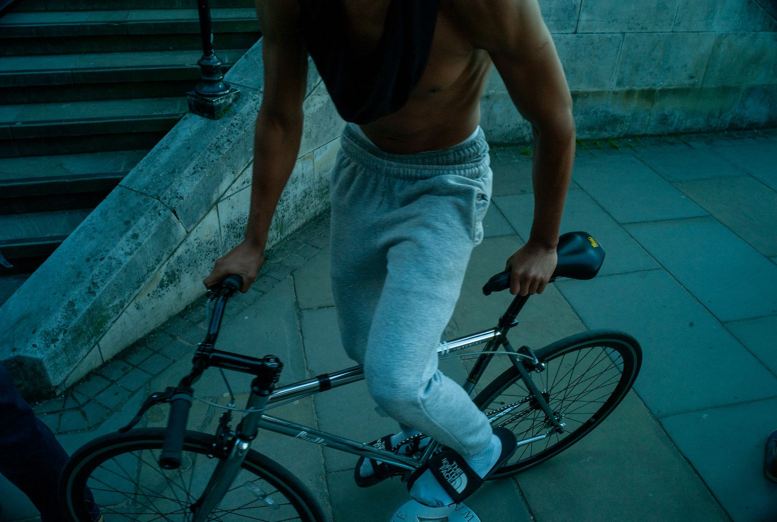 a shirtless man riding a bike down a street