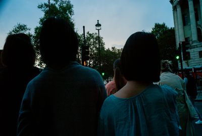 a group of people standing on the side of a road