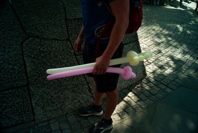 a man holding two plastic toothbrushes on a sidewalk