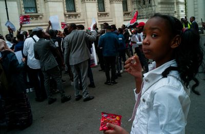 a young girl holding a candy bar in front of a crowd of people