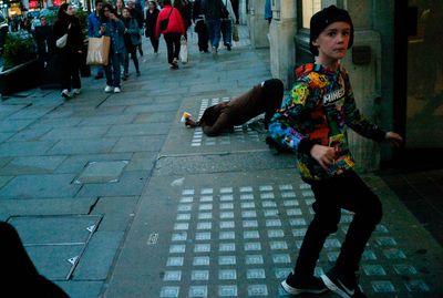 a young man riding a skateboard down a sidewalk