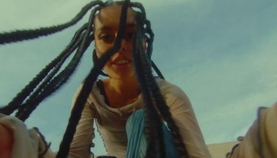 a woman with dreadlocks sitting on a bench