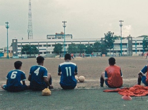 a group of men sitting on the ground next to each other