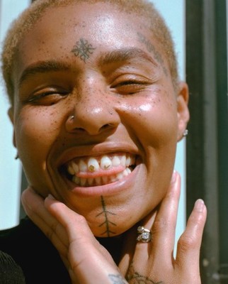 a woman with a tattoo on her face smiling