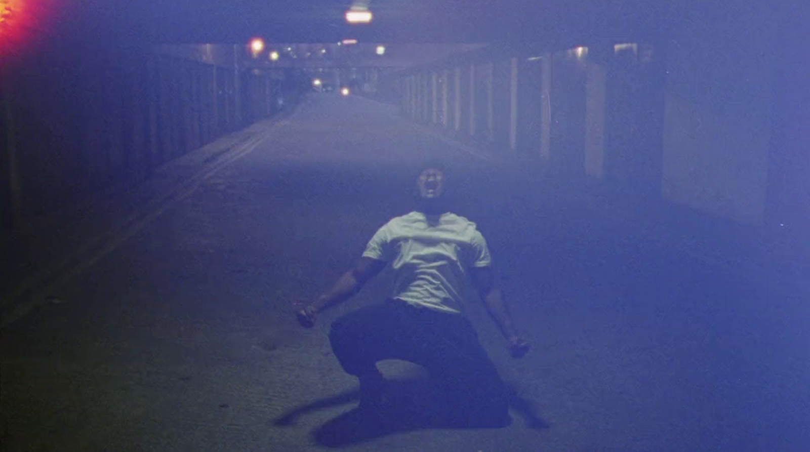 a man kneeling down in the middle of a street