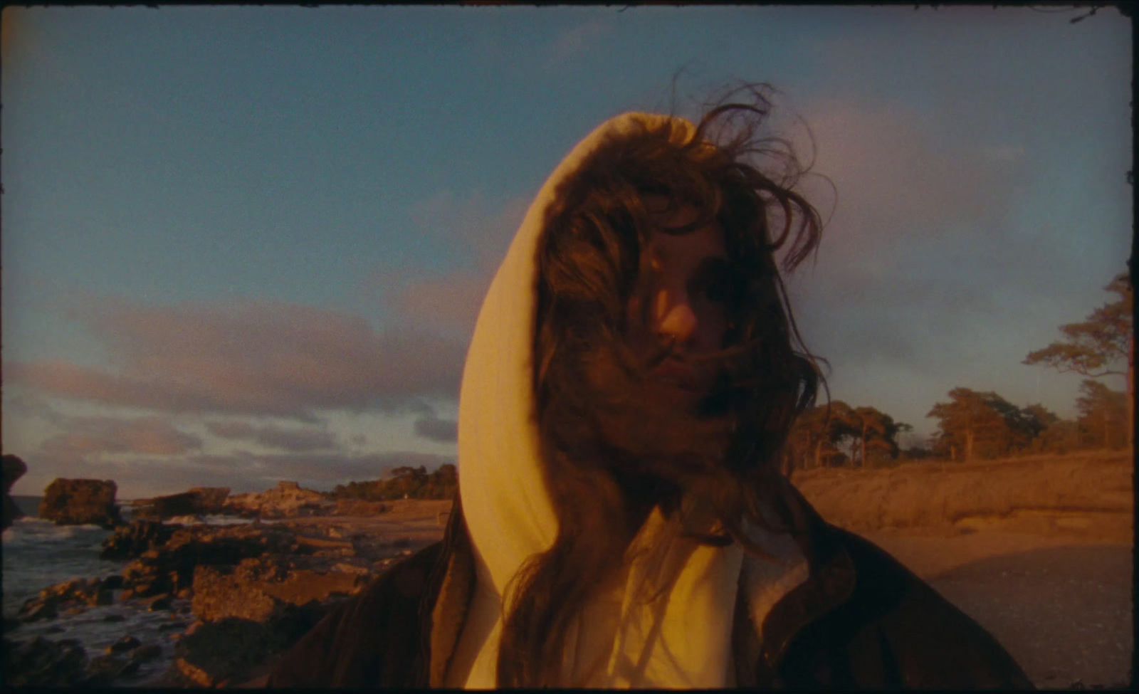 a man with long hair wearing a hoodie