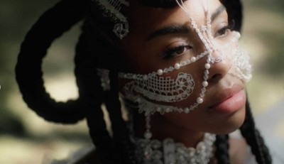 a woman with white face paint and beads on her face