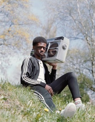 a man sitting in the grass holding a radio