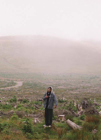 a man standing in a field on a cell phone