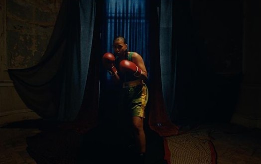 a man with a red boxing glove in a dark room