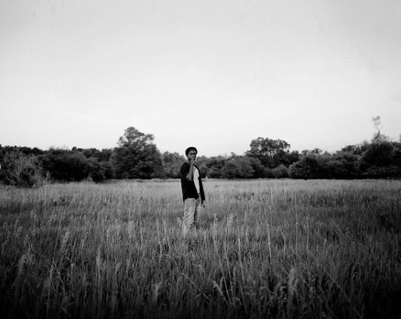 a man standing in a field of tall grass