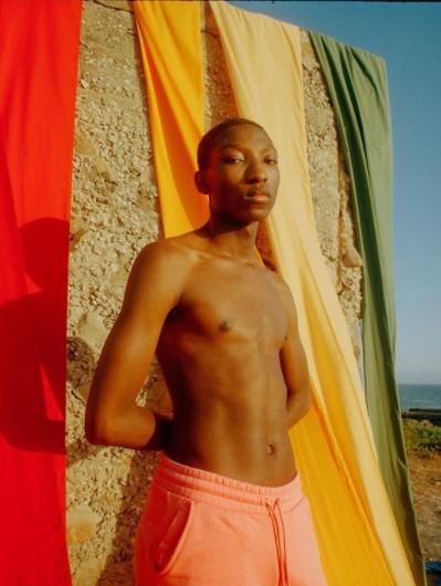 a man standing in front of a multicolored wall