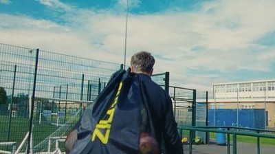 a man with a cape on walking towards a tennis court