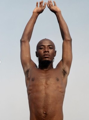 a shirtless man holding his hands up in the air