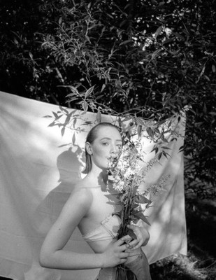 a woman holding a bunch of flowers in her hands