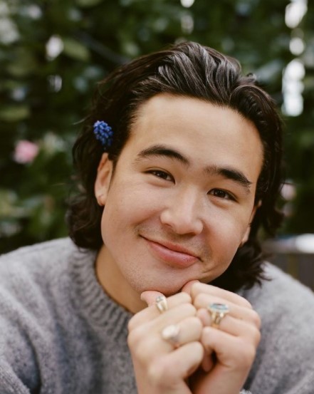 a man with a blue flower in his hair