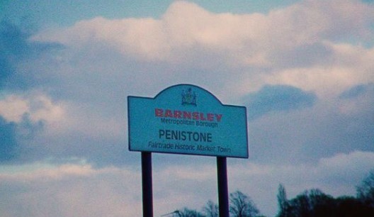 a blue sign that is in front of a cloudy sky