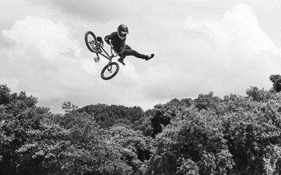 a man flying through the air while riding a bike