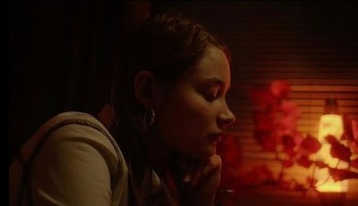 a woman sitting in front of a fire place