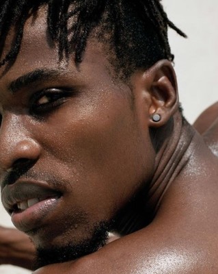 a close up of a man with a piercing on his ear