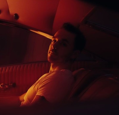 a man sitting in a car with a red light