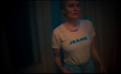 a woman standing in front of a mirror wearing a jean t - shirt