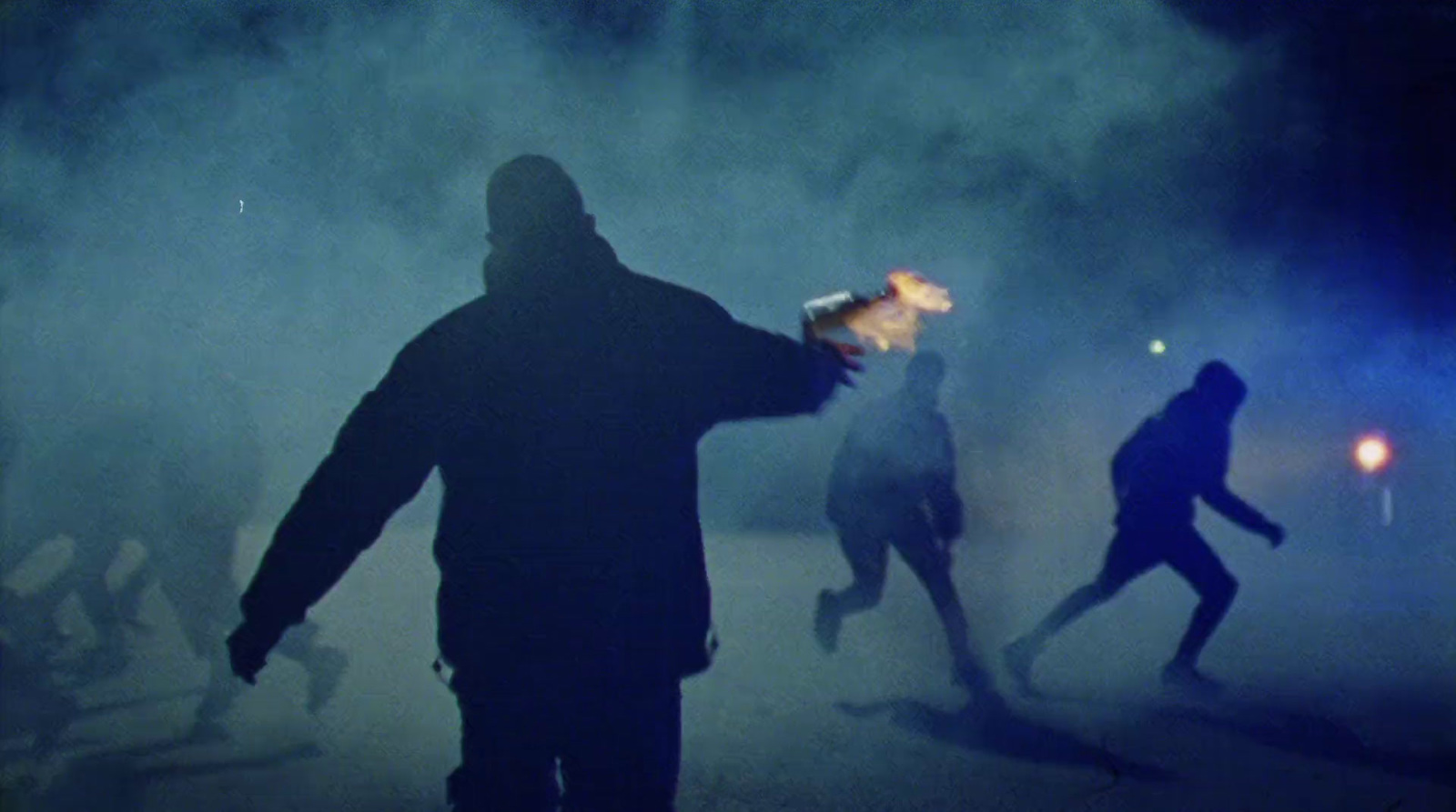 a group of people running through a foggy street