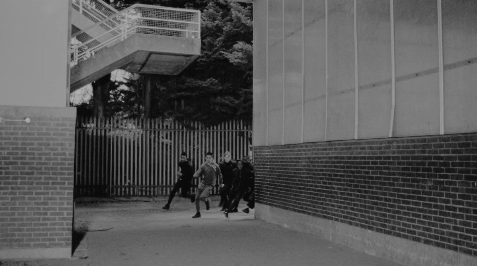 a black and white photo of people walking down a sidewalk