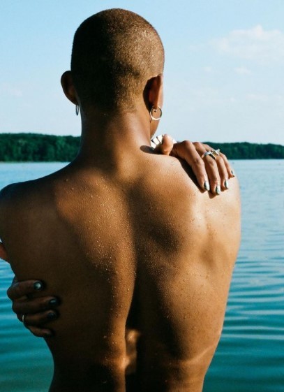 a person standing in the water with their back to the camera