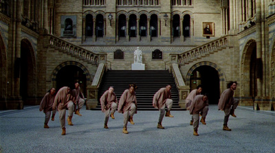 a group of men walking down a street in front of a building