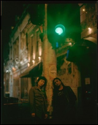 a couple of people standing next to a traffic light