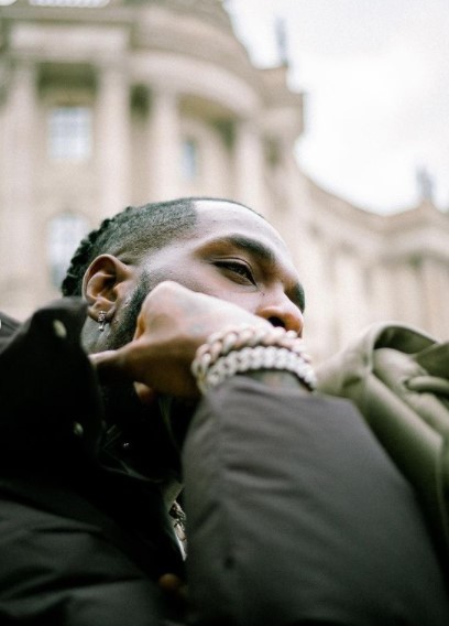 a man with his hand on his face in front of a building