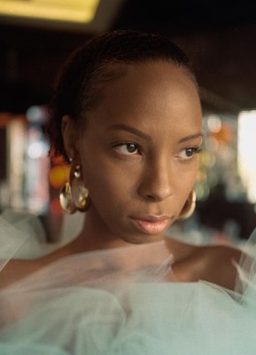 a woman in a white dress looking at the camera