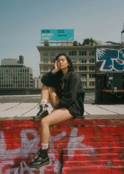 a woman sitting on top of a red brick wall