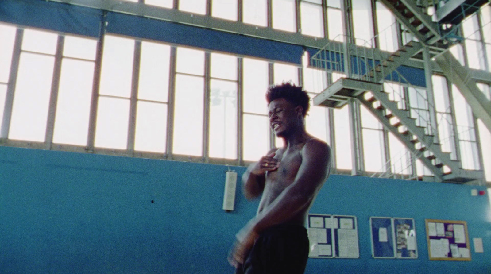 a man standing in a gym holding a frisbee