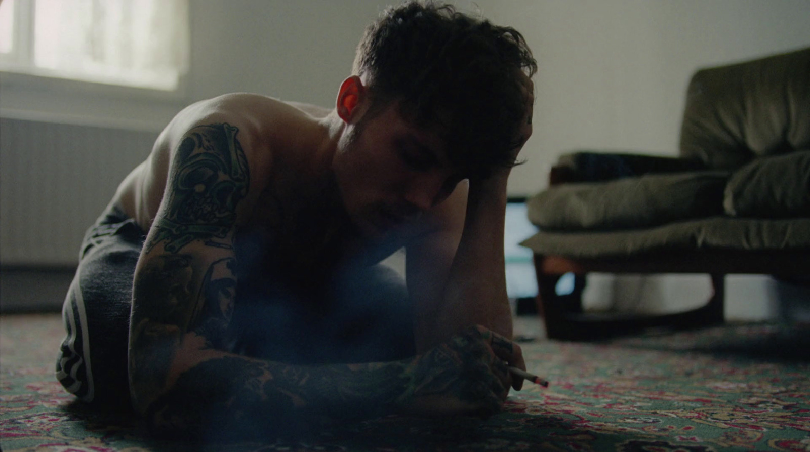 a man with tattoos laying on the floor