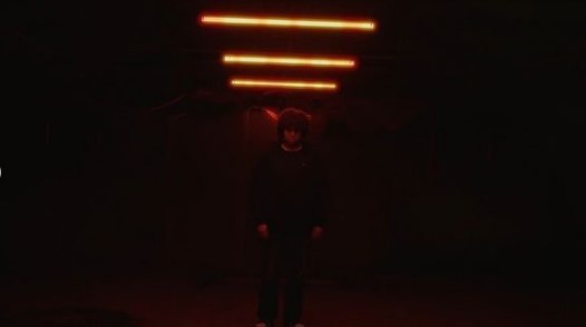 a person standing in a dark room with a red light