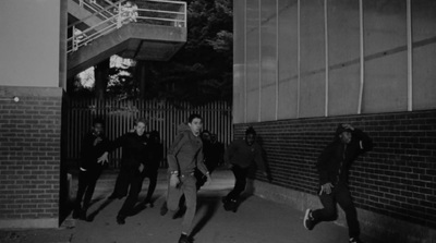 a group of men walking down a street next to a building