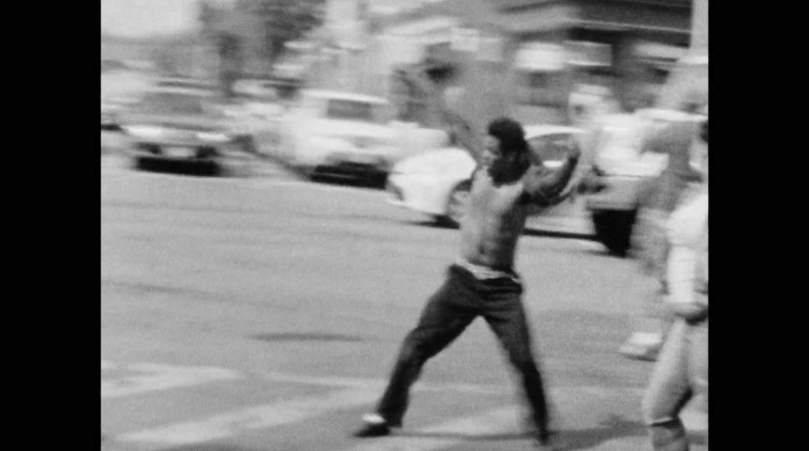 a black and white photo of a man throwing a frisbee