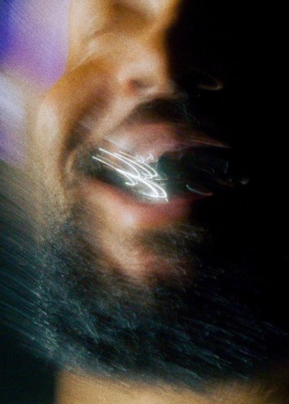 a close up of a man's face with a cell phone in his ear