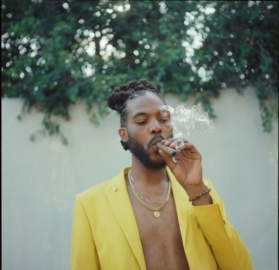 a man in a yellow suit smoking a cigarette